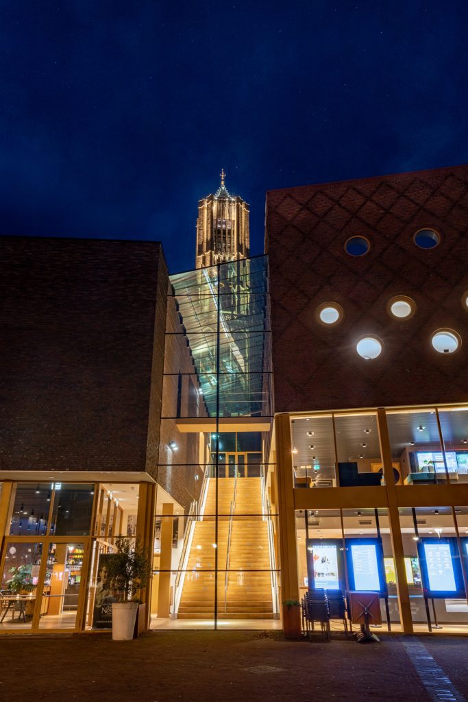 Focus Filmtheater Arnhem verlichte trapleuning buitenaanzicht met kerk