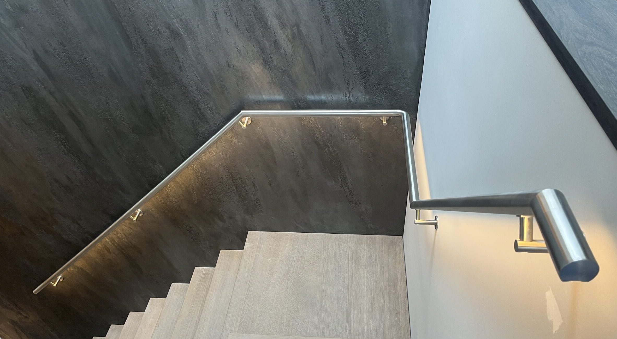 In de hoeken en vluchten verbonden RVS trapleuning met LED verlichting in een woning